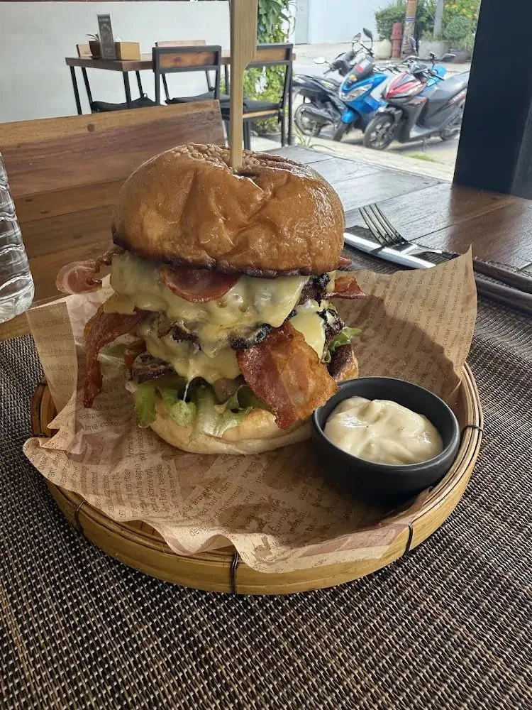 Bacon cheeseburger in a bamboo basket with garlic mayo