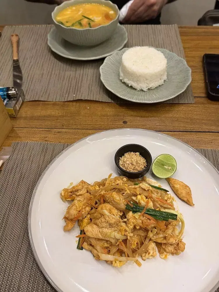Green curry with rice and a plate of pad Thai